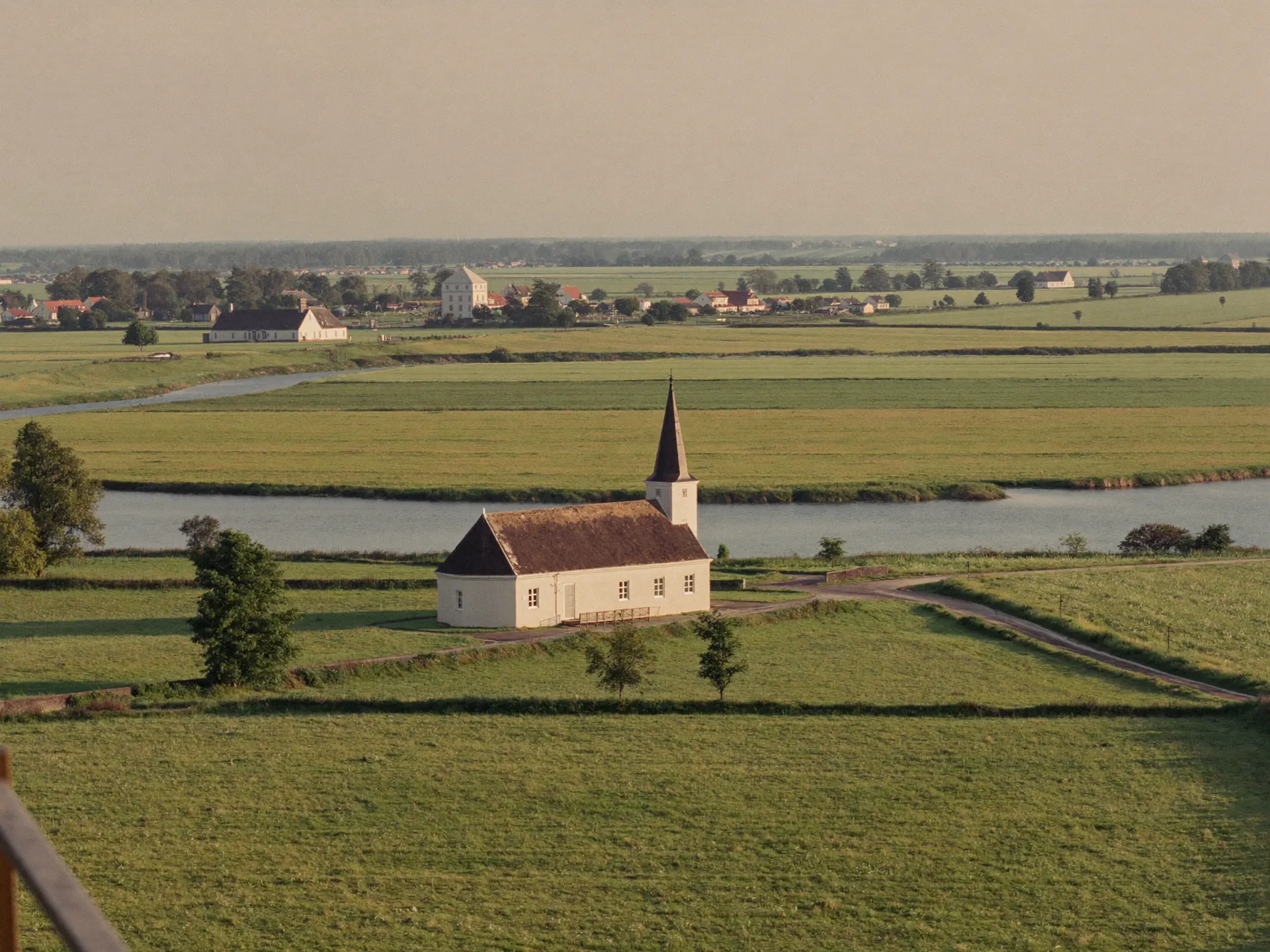 Dorpje met kerktoren tussen weilanden en waterwegen in de polder